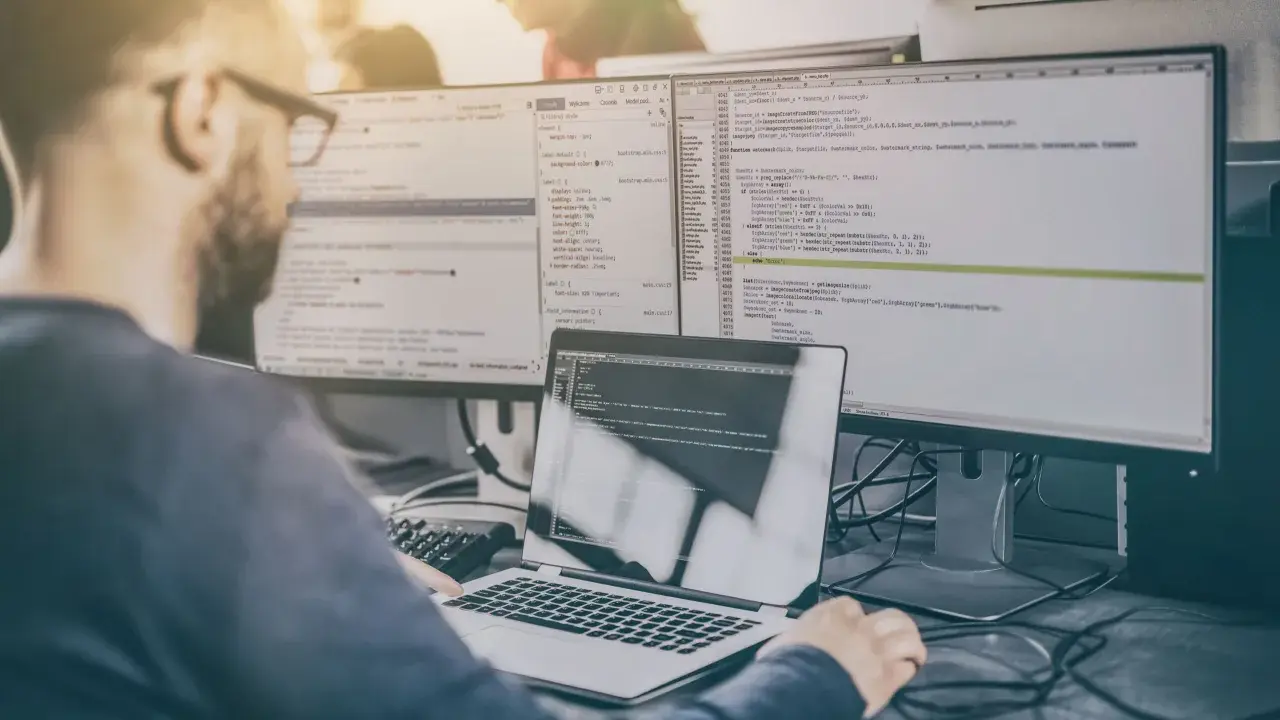 Programista analizuje kod, testując różne rodzaje testów manualnych.