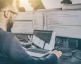 Programista analizuje kod, testując różne rodzaje testów manualnych.