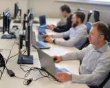 Zespół pracuje nad **static testing**, skupiony na ekranach komputerów w biurze.