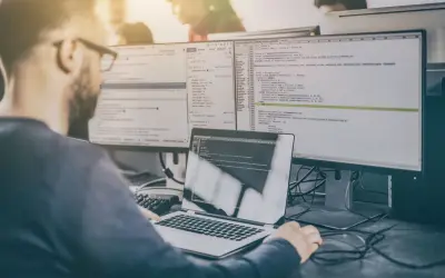 Programista analizuje kod, testując różne rodzaje testów manualnych.