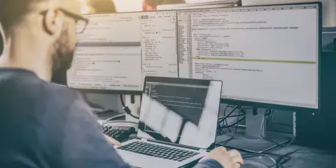 Programista analizuje kod, testując różne rodzaje testów manualnych.