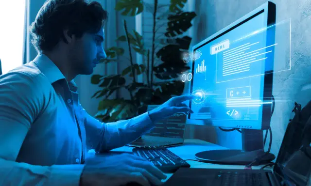 Programista analizuje kod na monitorze, szukając **defekt co to** jest. Widać fragmenty HTML i C++.