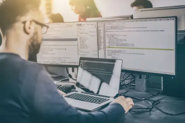 Programista analizuje kod, testując różne rodzaje testów manualnych.